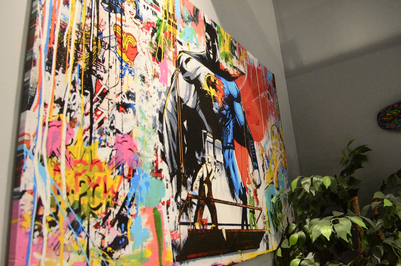 Pop-art canvas and greenery on the wall inside Legacy Barber Shop