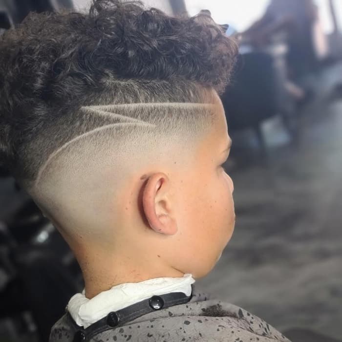 Curly top with a fade and a part design