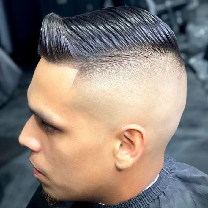 Slick pompadour over a high skin fade