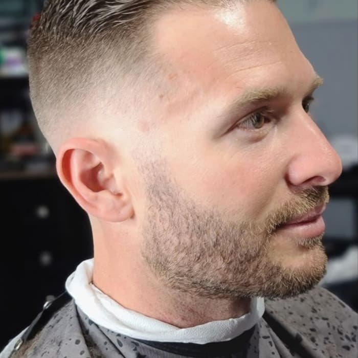 Combed-back cut with a fade and groomed beard